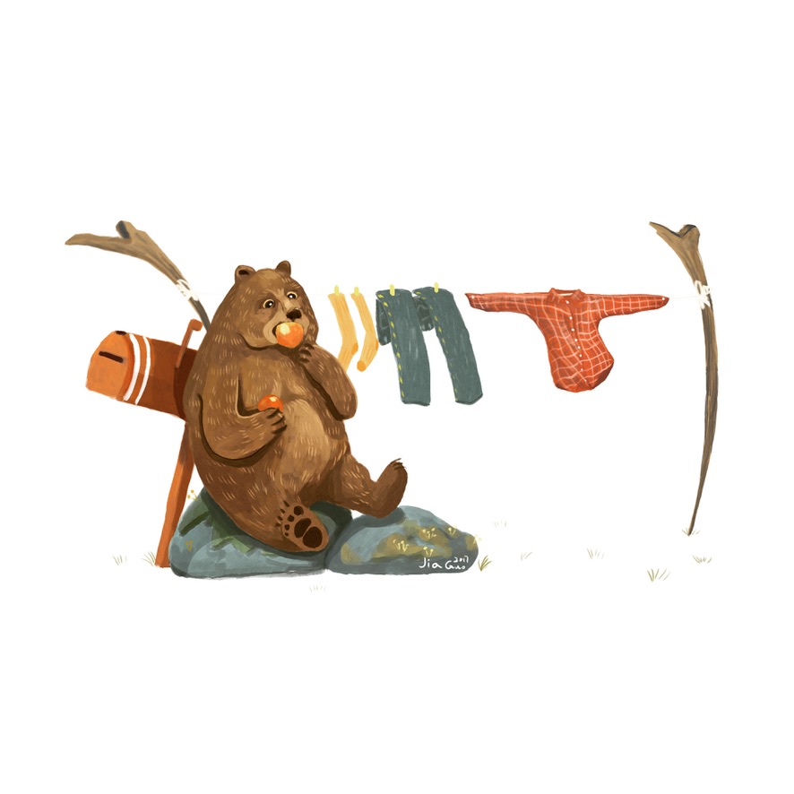 A bear drying clothes beside a branch.
